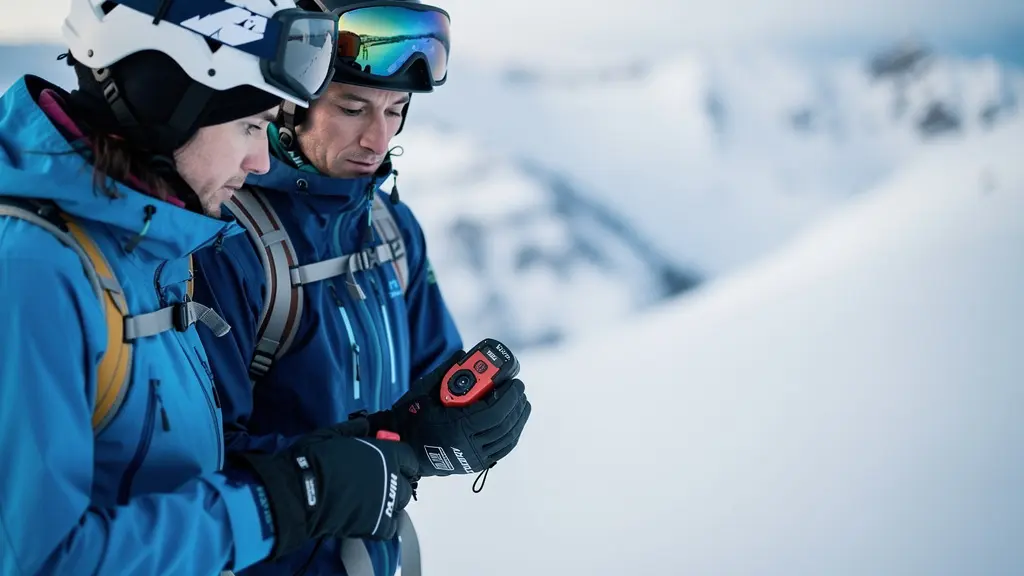 Deux skieurs en montagne réalisent un contrôle mutuel de leur matériel de sécurité avalanche avant de partir.